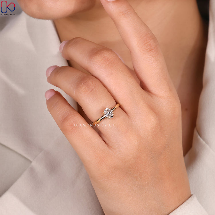 Oval diamond ring with tulip basket and four claws.