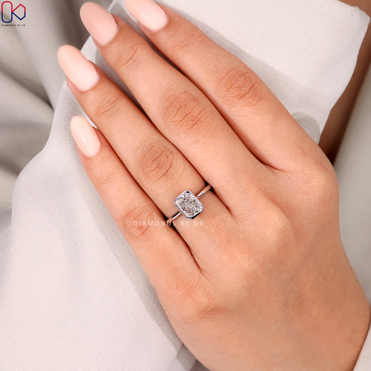 Radiant cut solitaire ring with secure bezel.