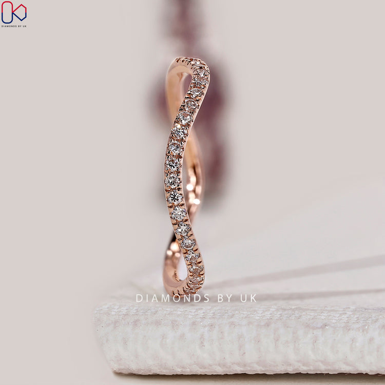 Round diamond eternity band with a flowing wave design.
