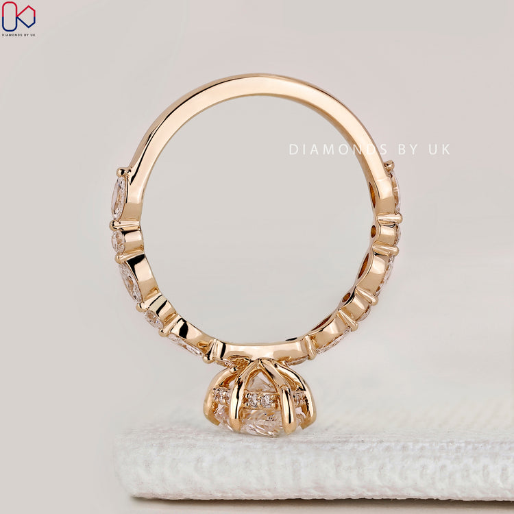 Pear cut ring with hidden halo and round diamonds.