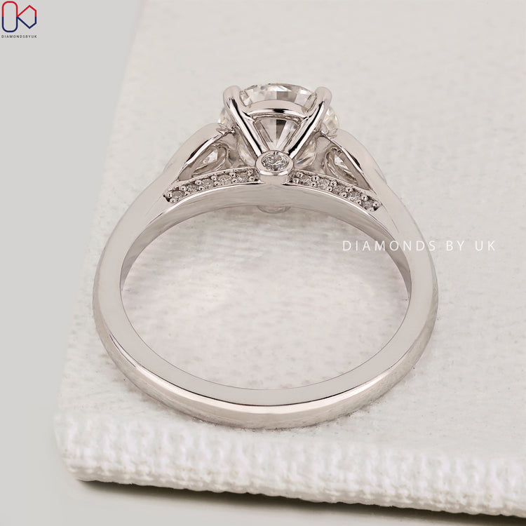 Handmade round cut diamond ring with bridge accents.
