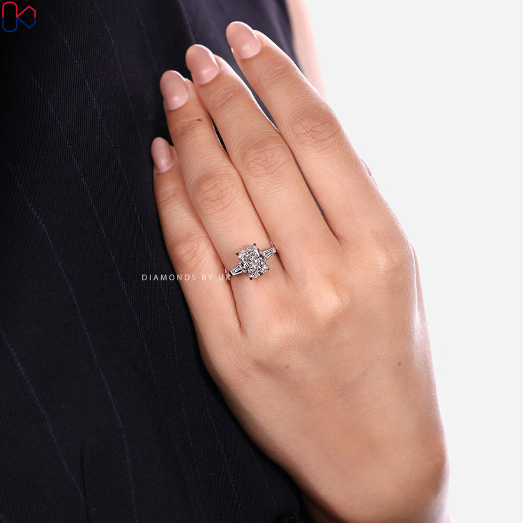 Three stone cushion diamond ring with baguette side stones.
