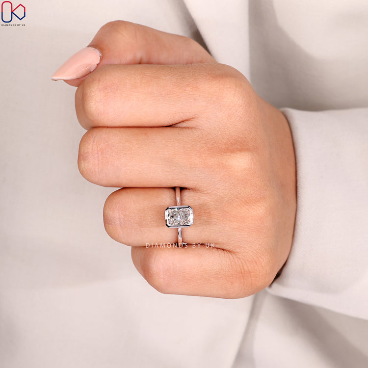 Radiant diamond ring with solitaire style and bezel.