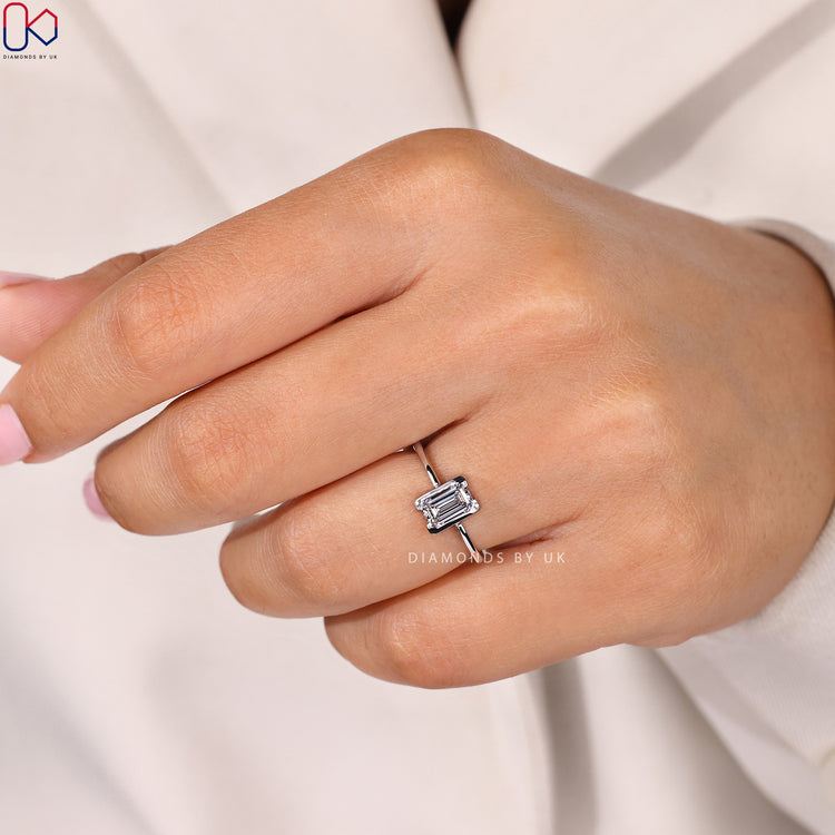Emerald cut ring with tapered shank and half bezel.
