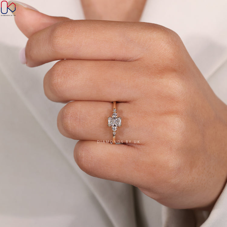 Round side stone radiant cut ring with prongs.