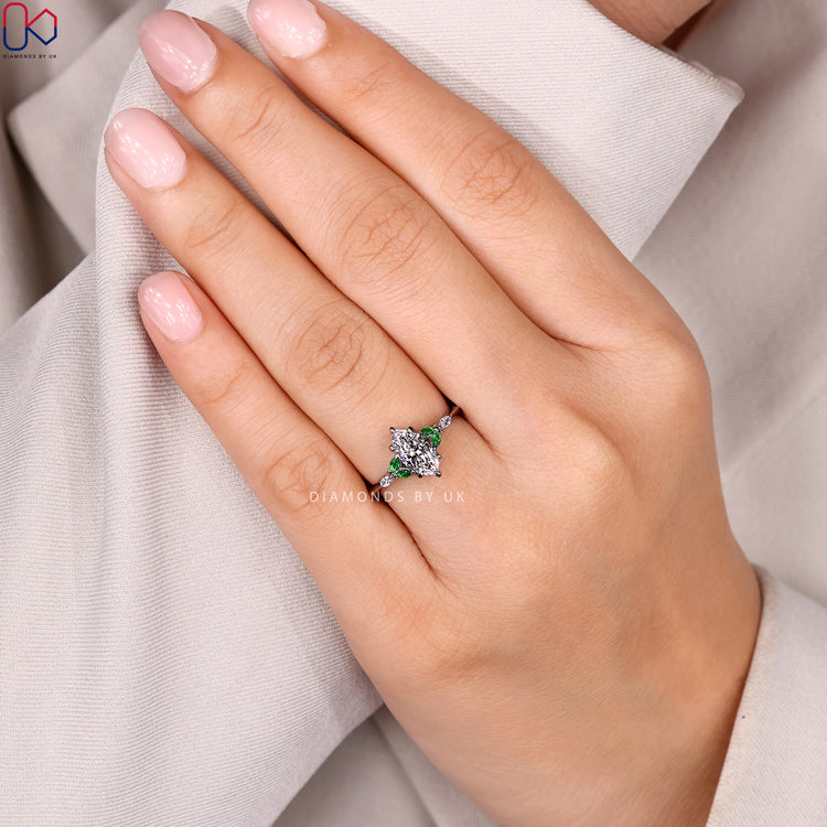 Marquise diamond ring with dark green emeralds.