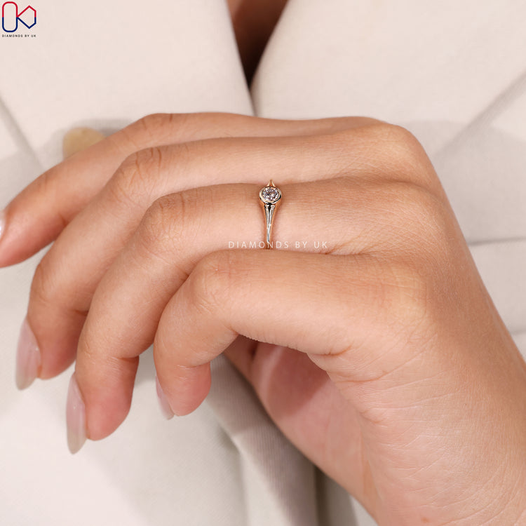 Round diamond ring with a simple bezel setting.