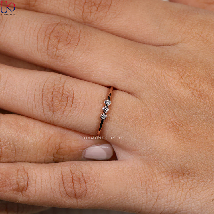 Round diamond band with three stone bezel setting.
