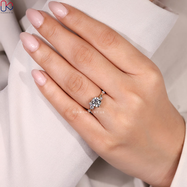 Round cut diamond ring with cluster style.