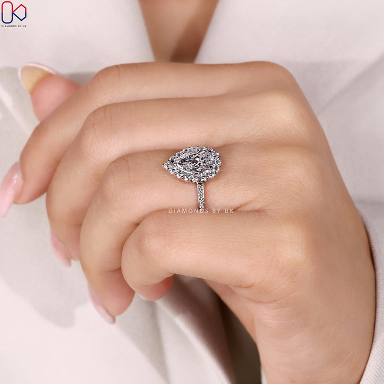 Lab grown pear ring with halo and round diamonds.