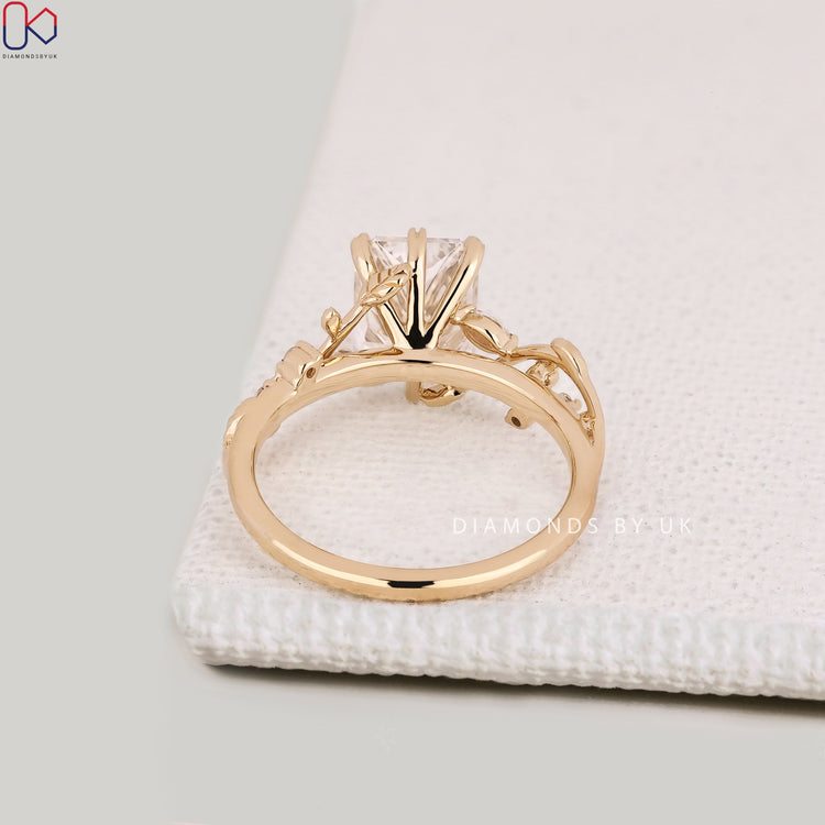 Handmade radiant cut diamond ring with leaf style prongs.