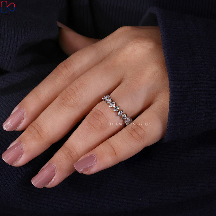 Lab grown diamond band with round stones and prongs.