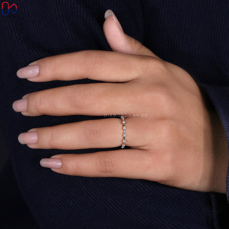 Round diamond wedding band with distance pavé design.
