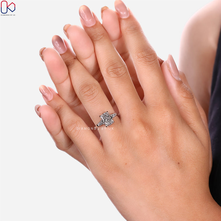 Cushion diamond ring with tapered baguette side stones.
