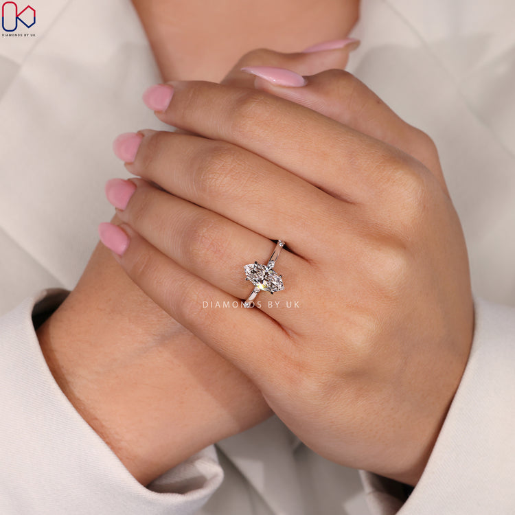 Marquise cut diamond ring with claw prongs and pavé.
