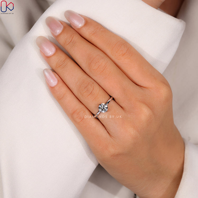 Round cut solitaire ring with compass prongs.
