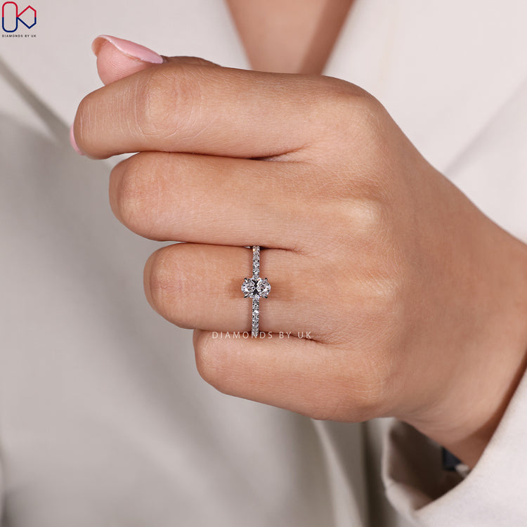 Oval cut engagement ring with pavé diamond band.