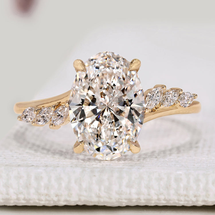 Oval diamond engagement ring with marquise side stones.