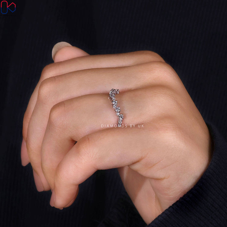 Round diamond band with curved design and prongs.