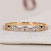 Marquise and round diamond band with shared prongs.
