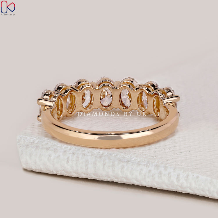 Oval diamond band with prong set half eternity design.
