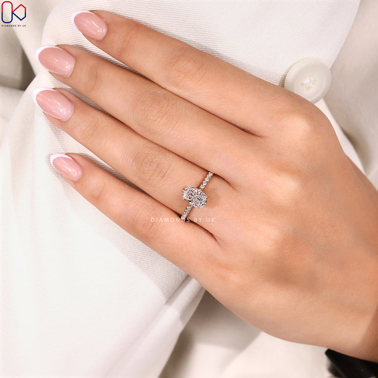 Cushion cut diamond ring with pavé round diamonds.

