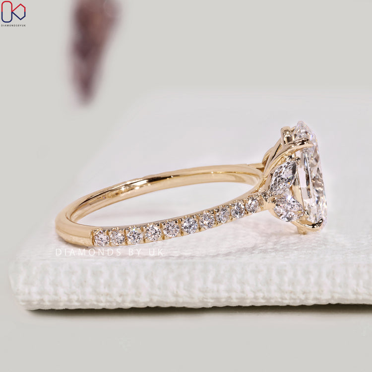 Lab grown oval diamond ring with marquise side stones.
