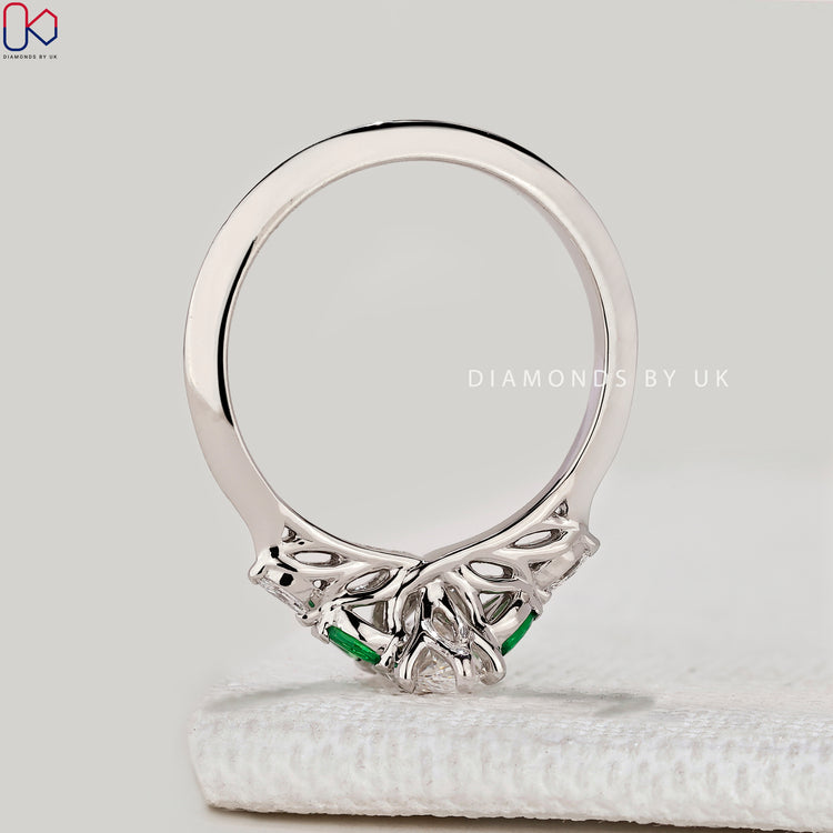 Marquise ring with green emerald side stones.