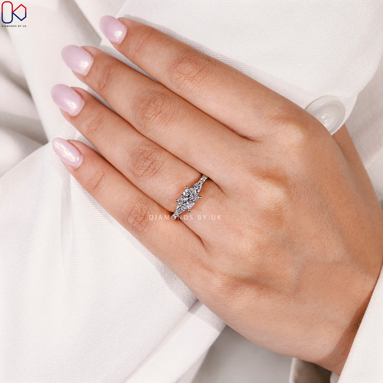 Princess cut ring with pear side stone design.