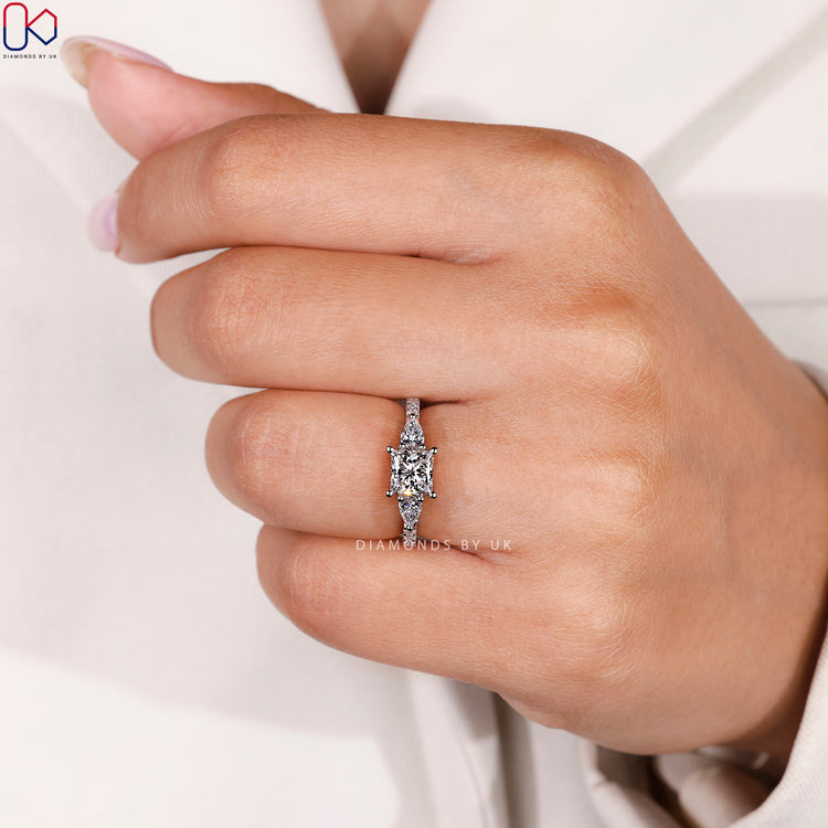 Three stone princess ring with pavé diamonds.