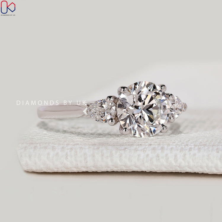 Round cut lab grown diamond ring with three stones.