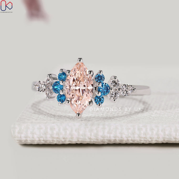 Pink centre diamond with round aquamarine side stone

