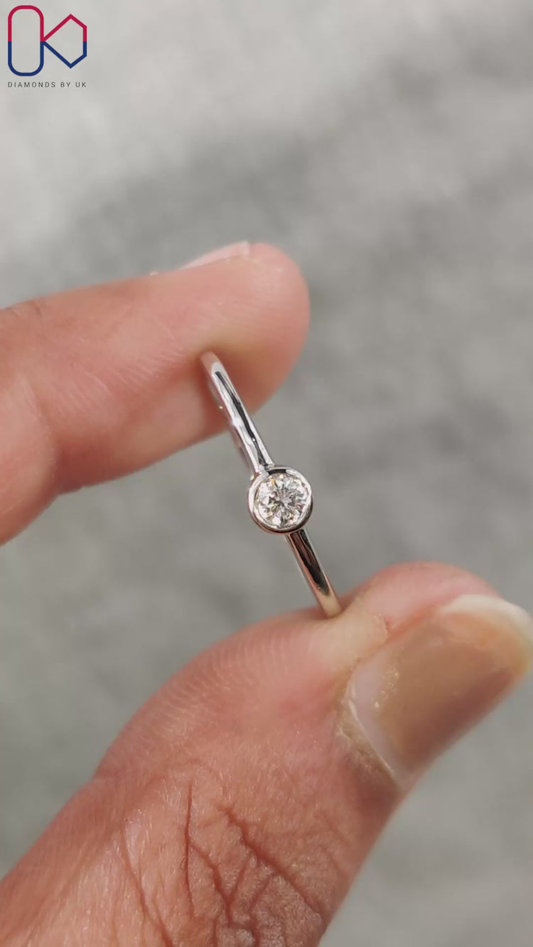 Bezel set engagement ring featuring a round cut diamond.
