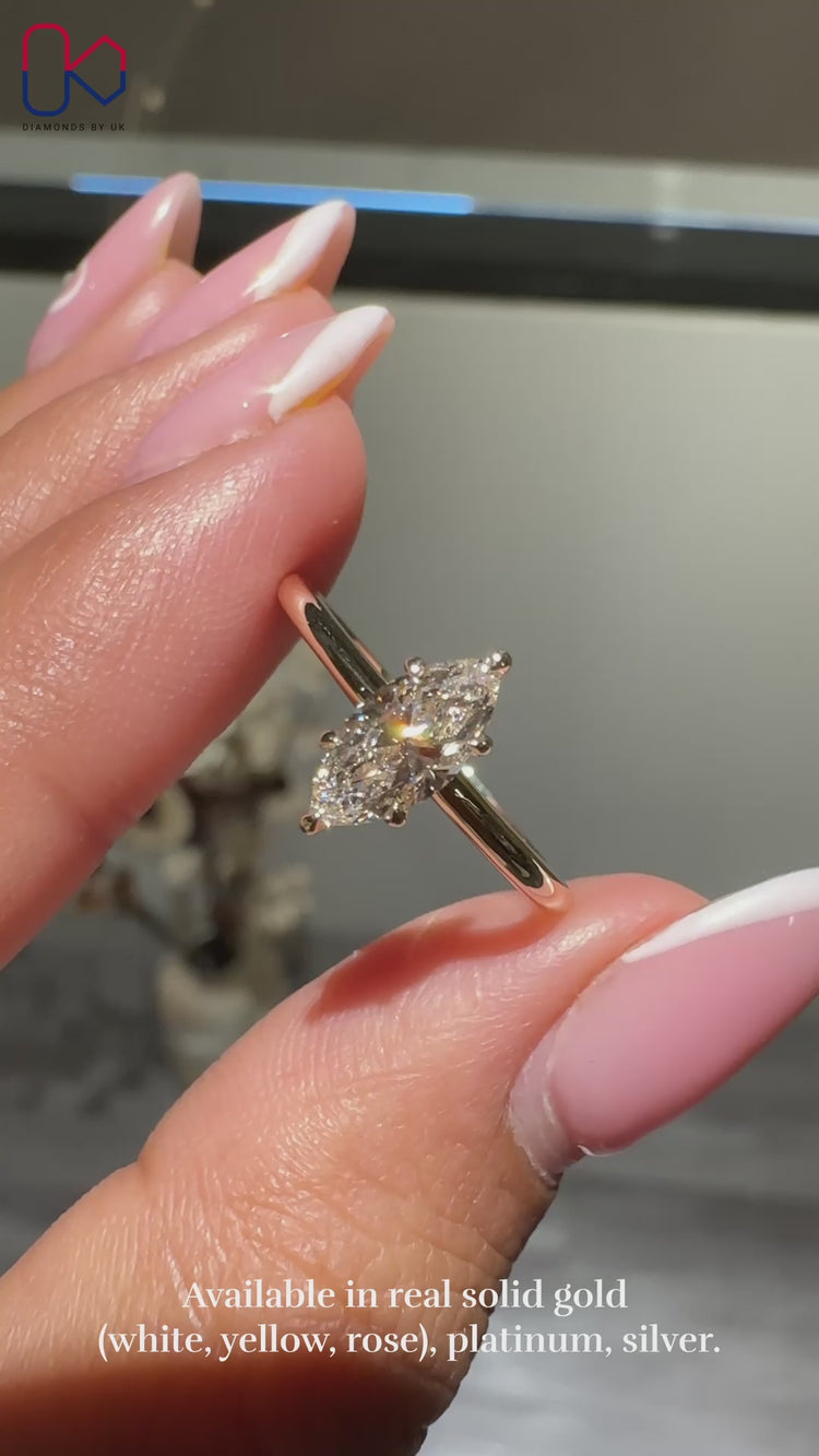 Gold marquise engagement ring with a six claw prong setting.
