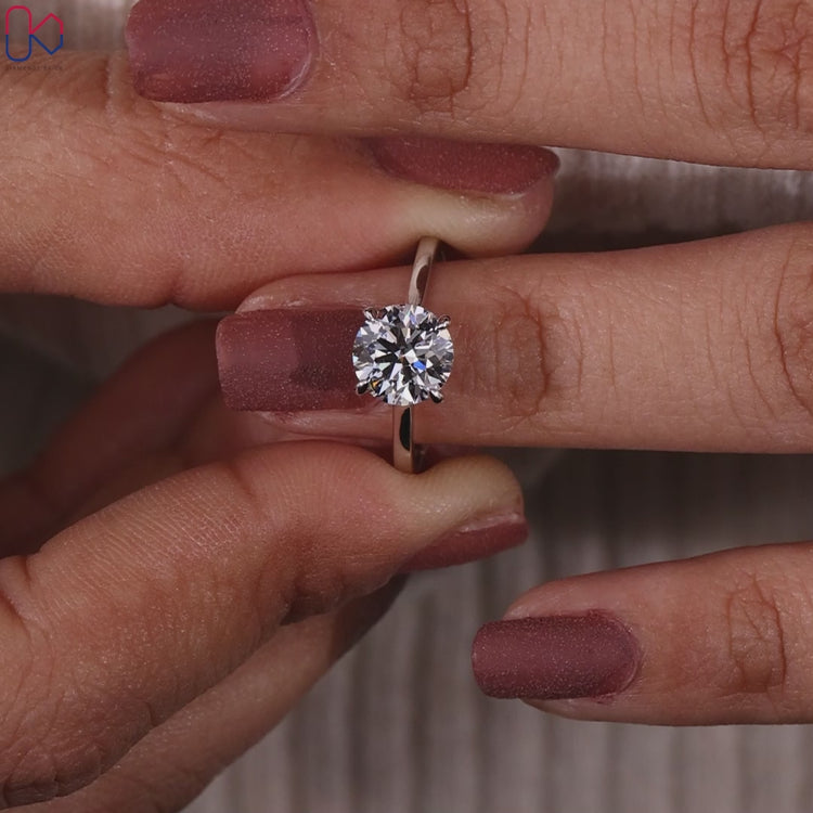 Round diamond engagement ring in a minimalist solitaire style.
