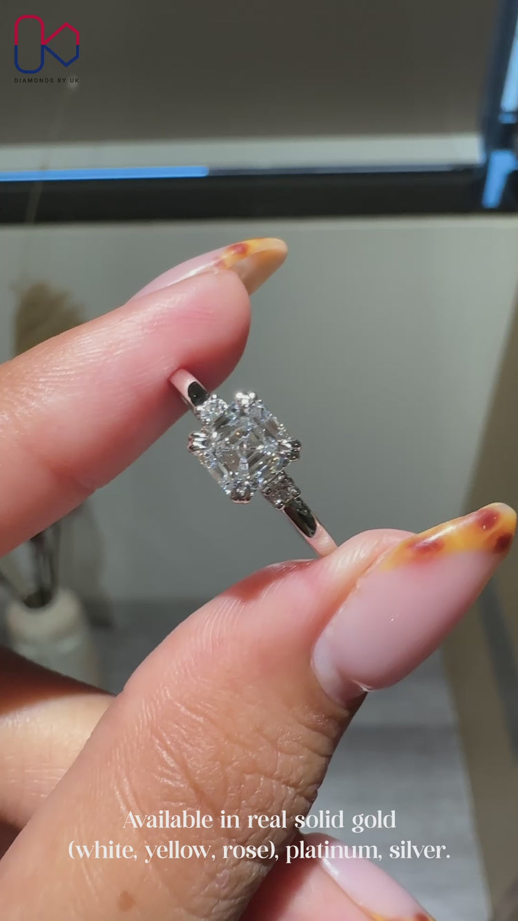 Three stone ring with Asscher cut center and round diamonds.
