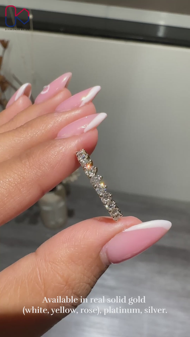 Prong set round diamond wedding band with a half eternity design.
