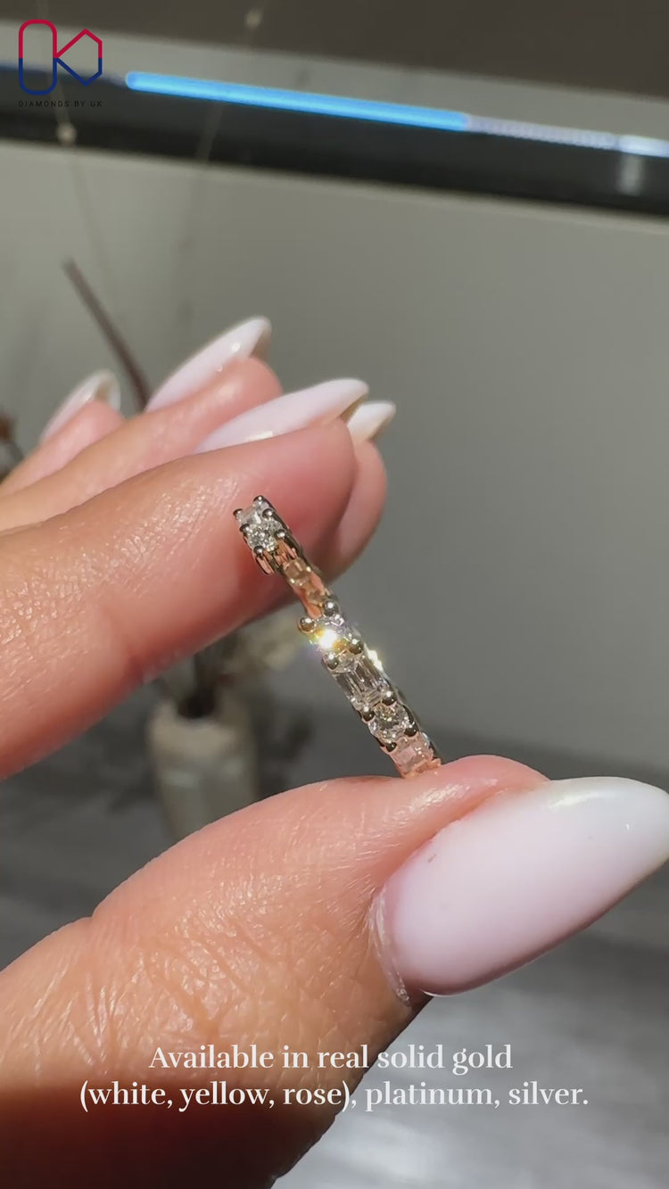 Open gap wedding band with emerald and round diamonds.
