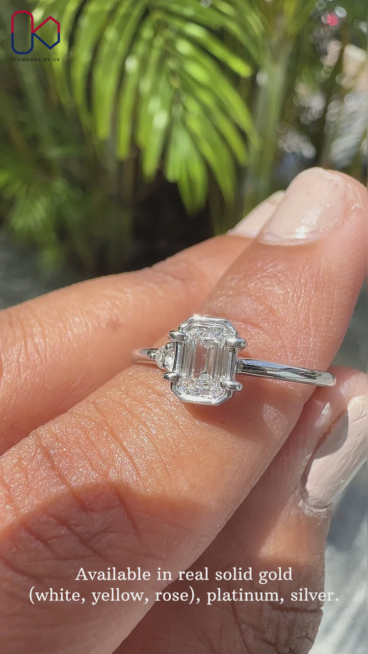 Round and emerald cut diamond ring set in a bezel setting ring.