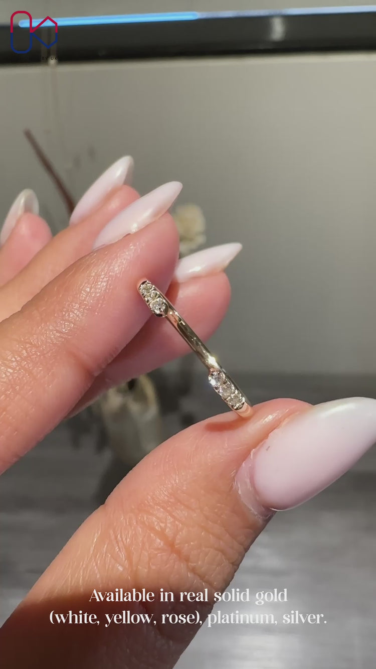 Round cut diamond band designed with an open gap in prong setting.
