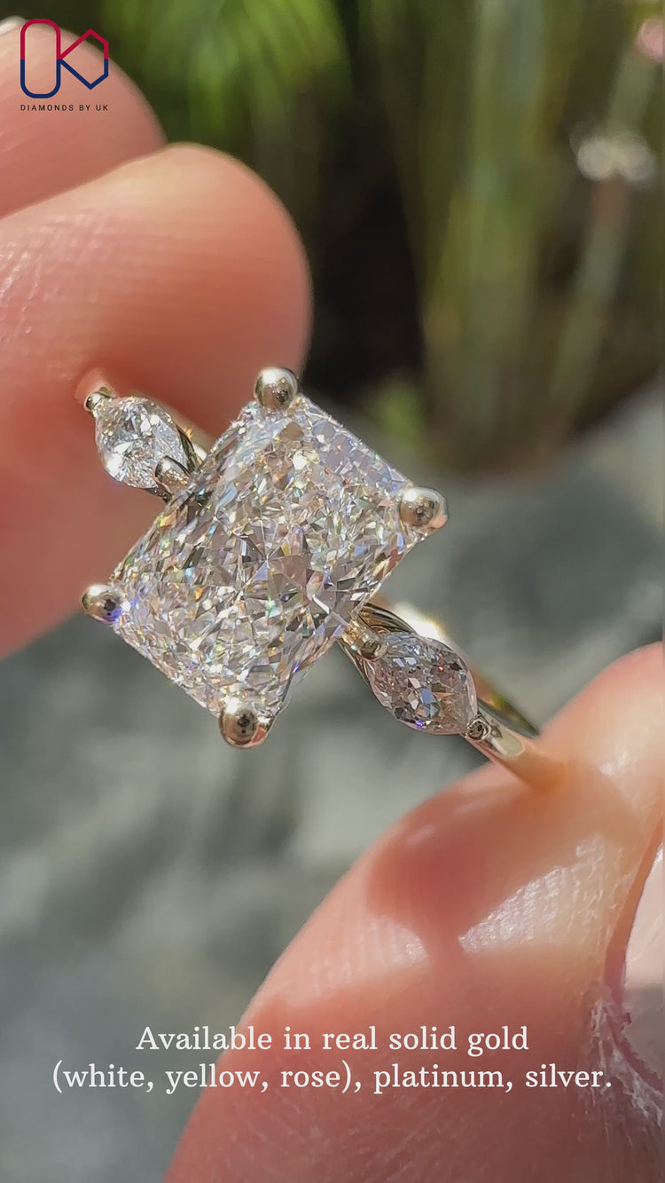 3 stone ring featuring a radiant cut diamond ring and yellow gold diamond ring band.
