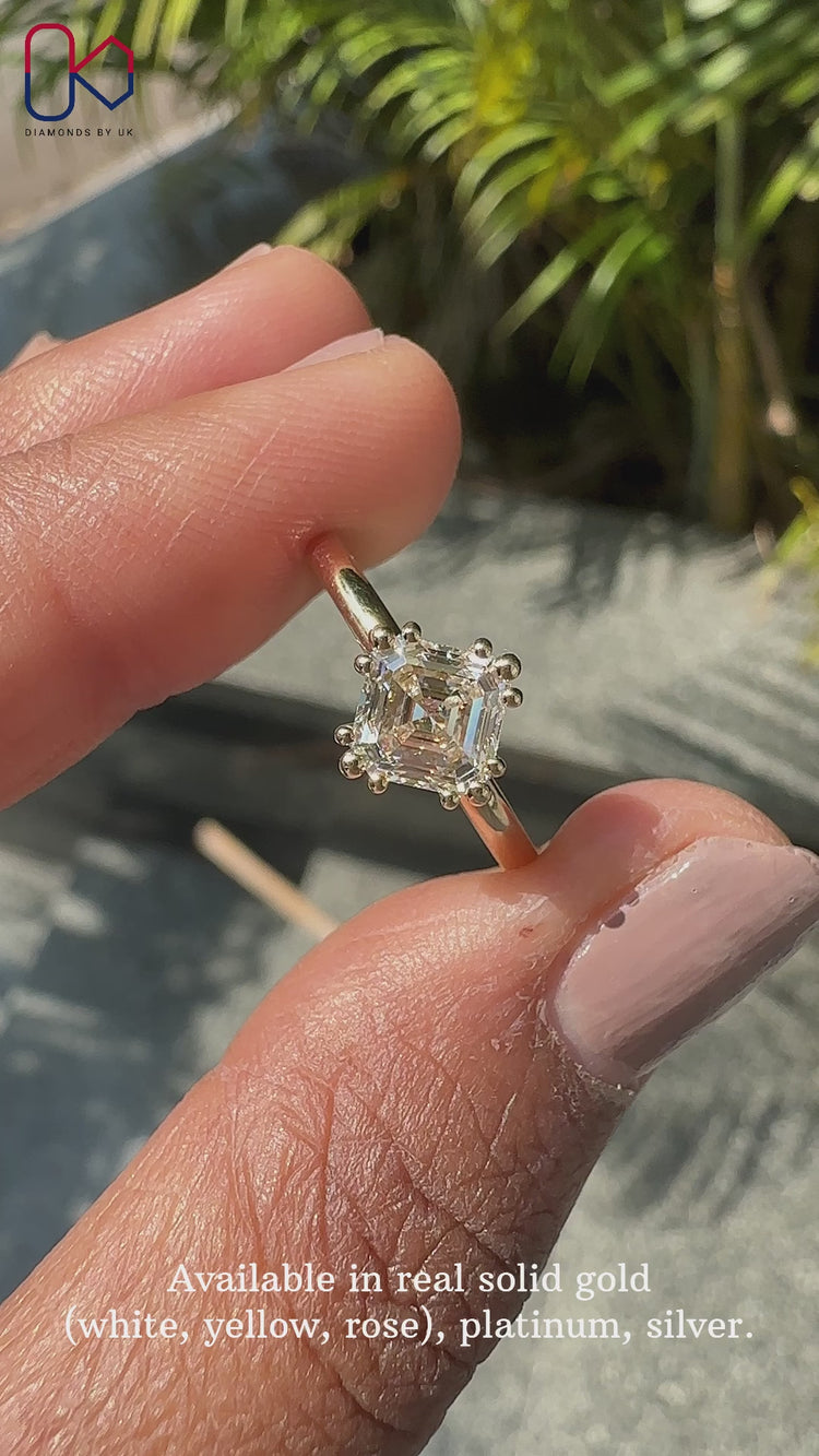 Elegant asscher cut solitaire ring with a yellow gold band.
