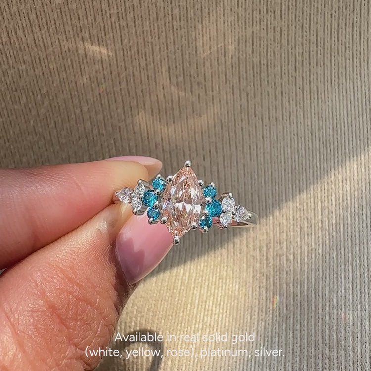 Marquise engagement ring with round aquamarine stones
