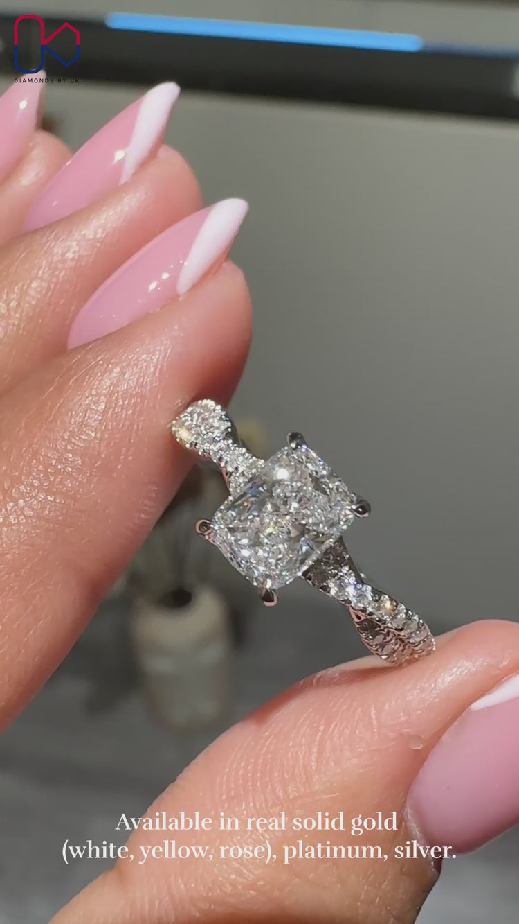 Elongated Cushion Diamond Ring with round side diamonds, set in a twisted band for a unique design.
