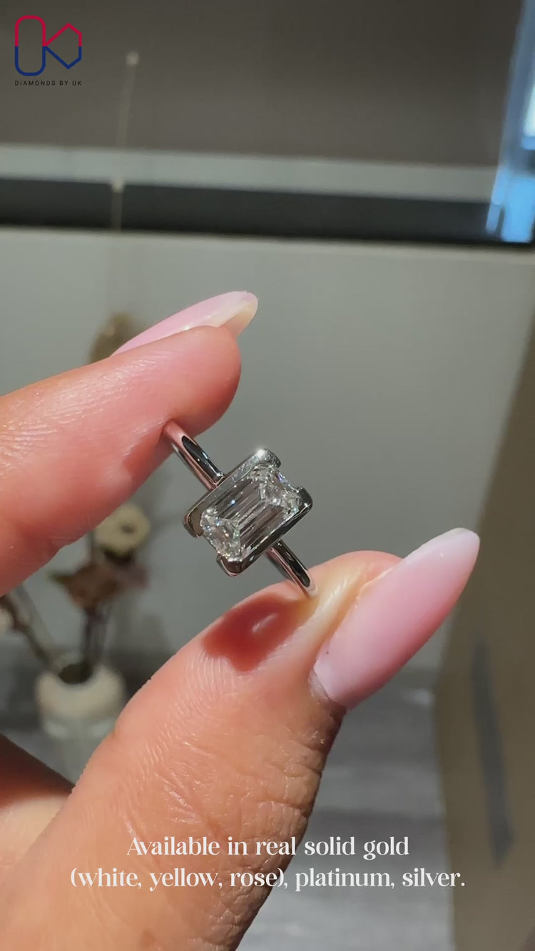 Emerald cut solitaire ring with tapered shank.
