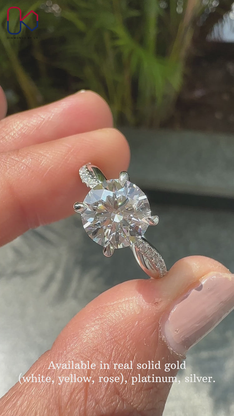 Twisted band engagement ring featuring a brilliant round diamond engagement ring.
