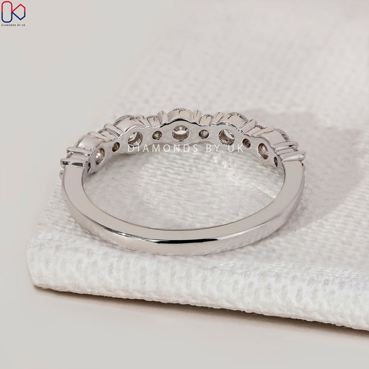 Round diamond wedding band with half eternity setting.
