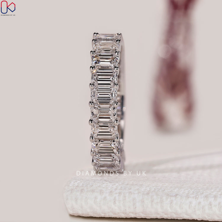 Lab grown emerald cut diamond band with half eternity.
