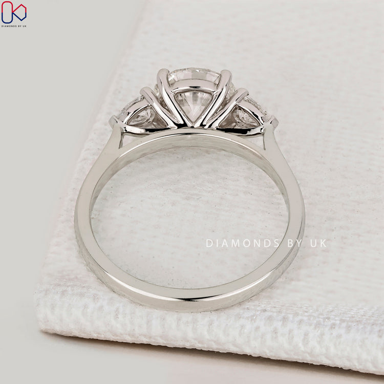 IGI Certified round cut diamond ring with pear stones.