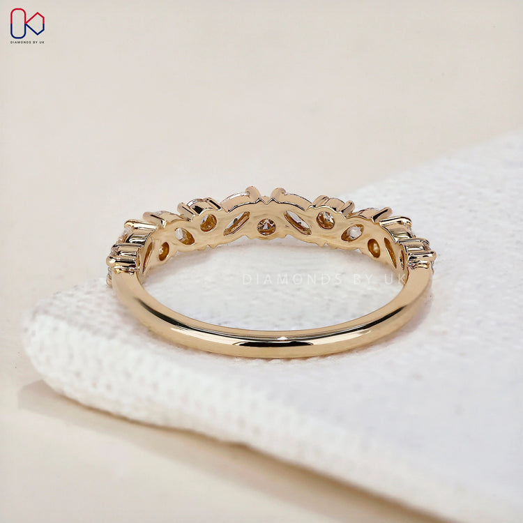 Round diamond wedding band made in yellow gold with handmade detailing.
